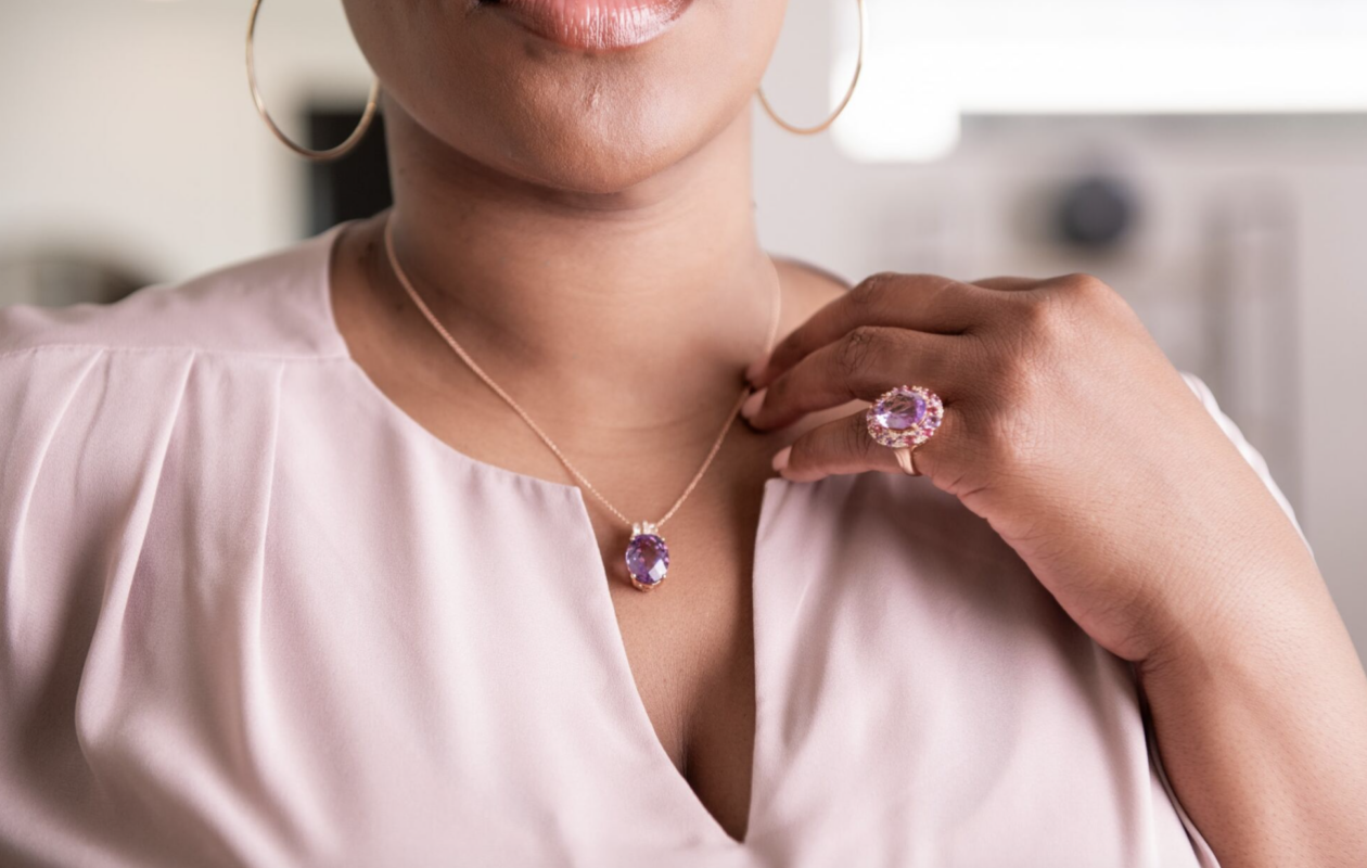 A model showcasing a gemstone necklace and cocktail ring.